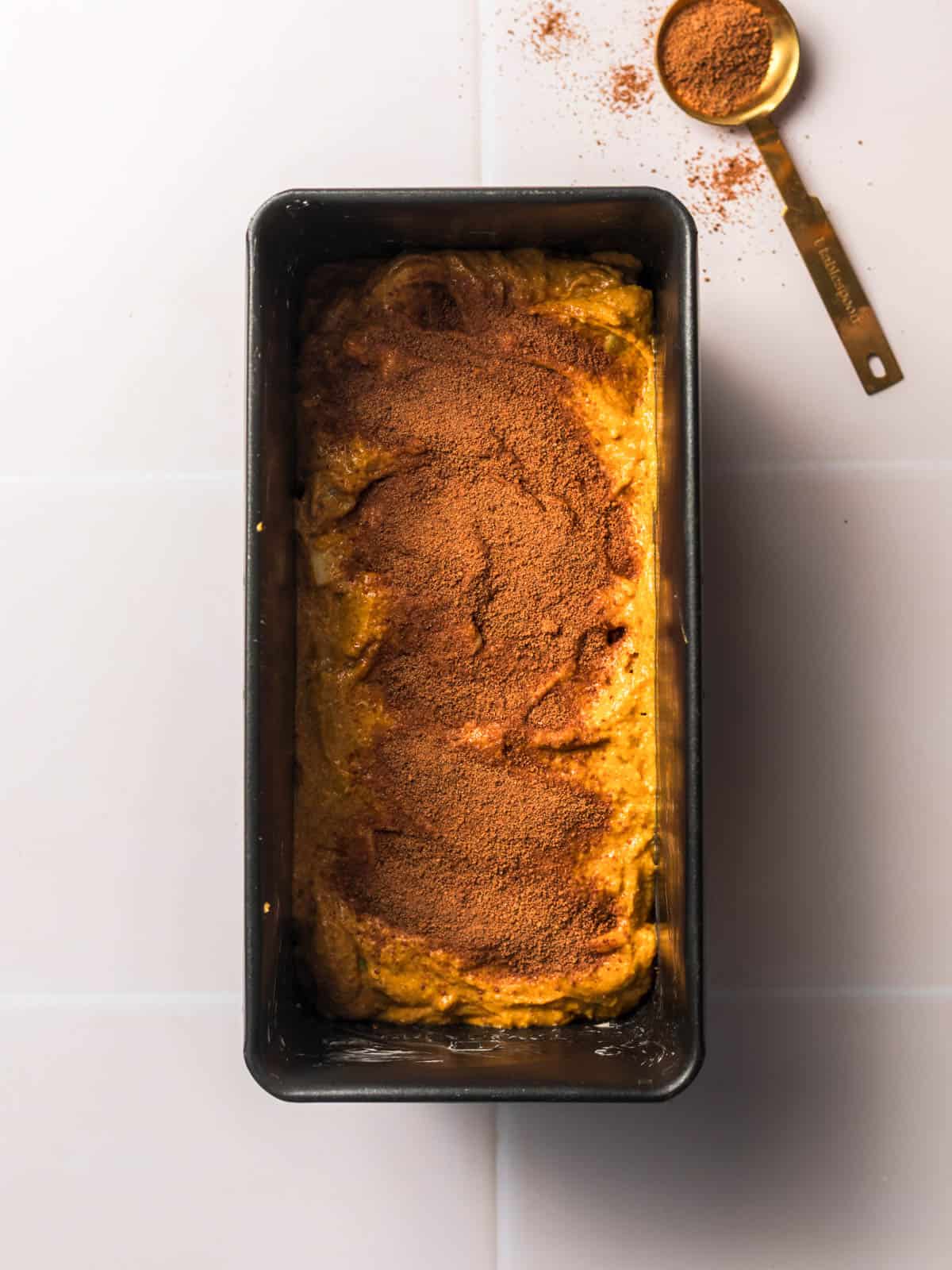 vegan pumpkin loaf with a cinnamon topping in baking dish