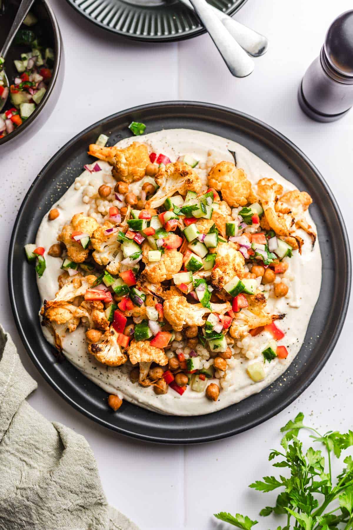 roasted cauliflower and chickpeas on tahin and israeli couscous