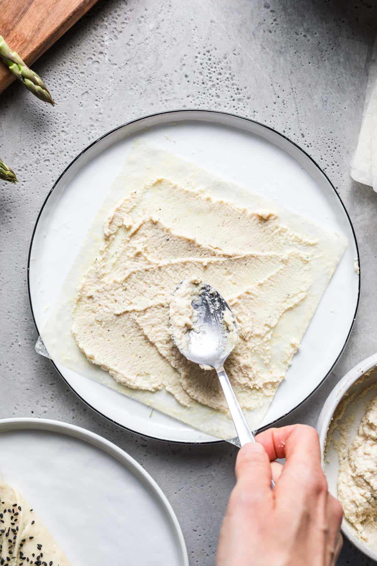 Spreading almond filling onto a softened rice paper sheet