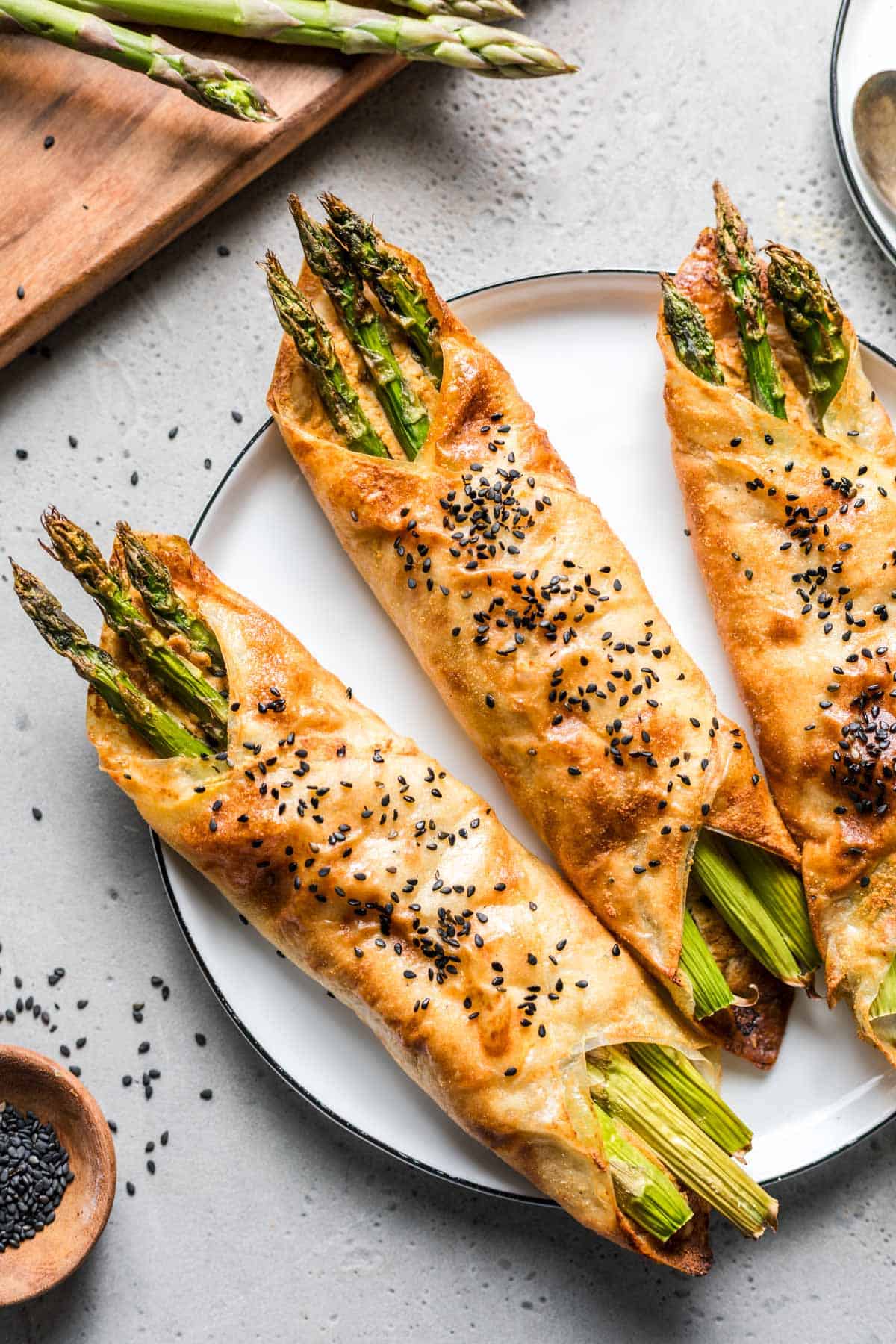 Vegan asparagus rice paper parcels with sweet mustard dressing on a plate