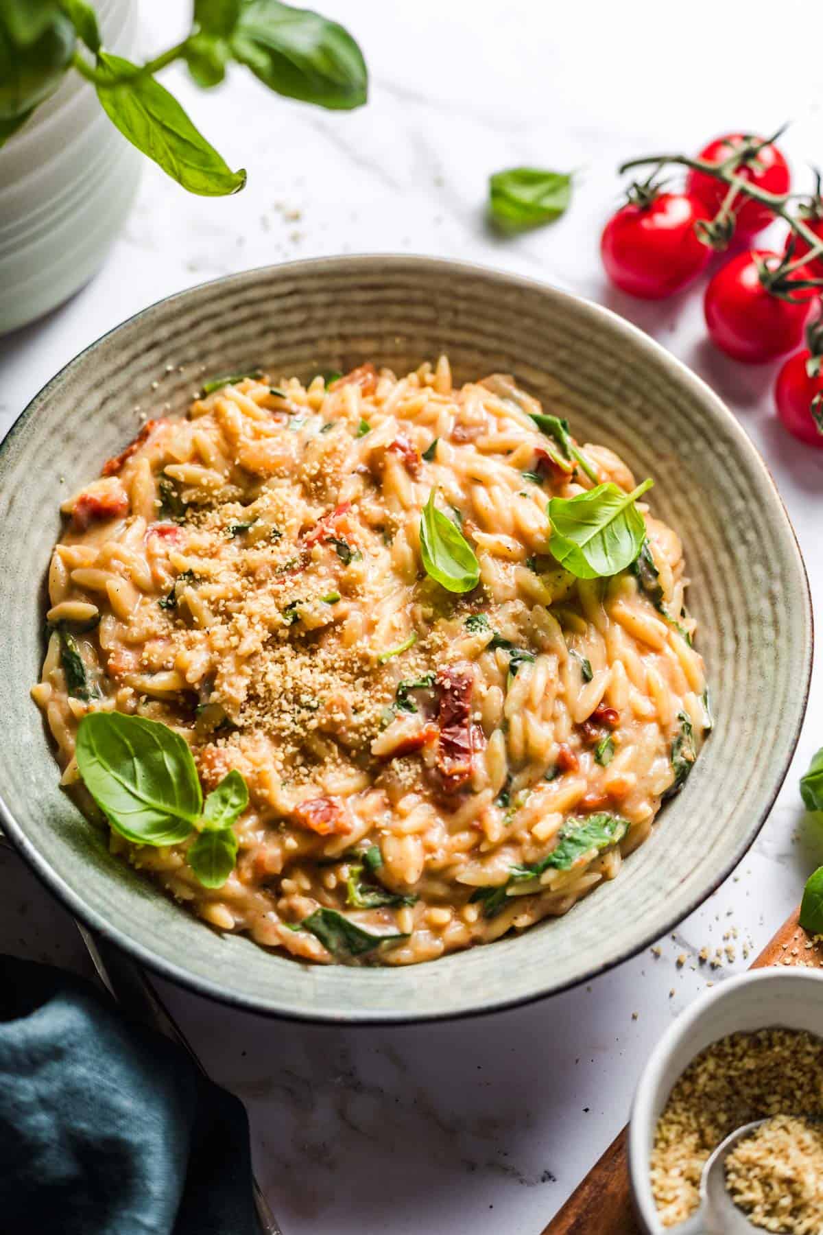 Creamy vegan tomato orzo in a bowl with fresh basil