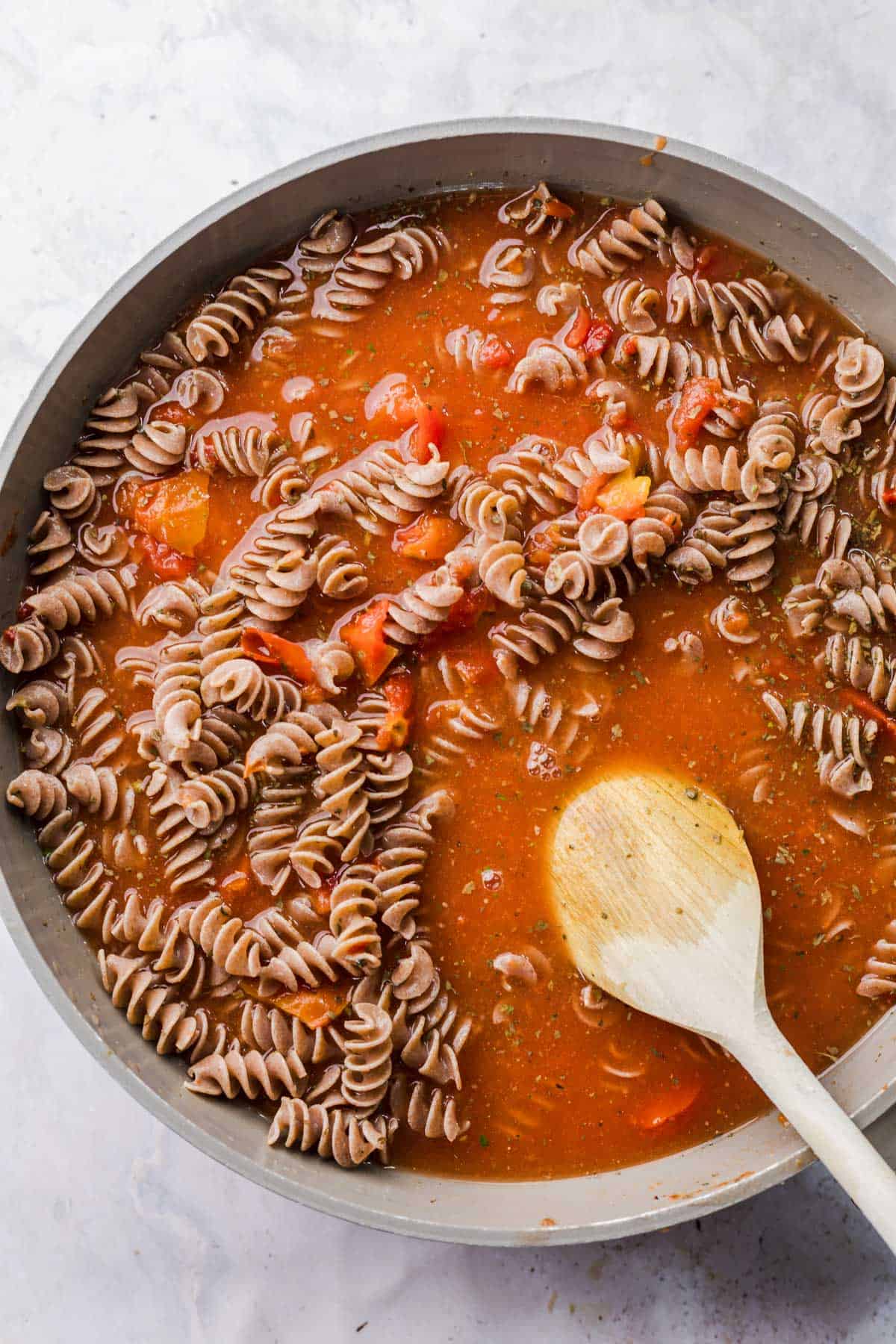 One-pot pasta simmering in tomato sauce with vegetable broth