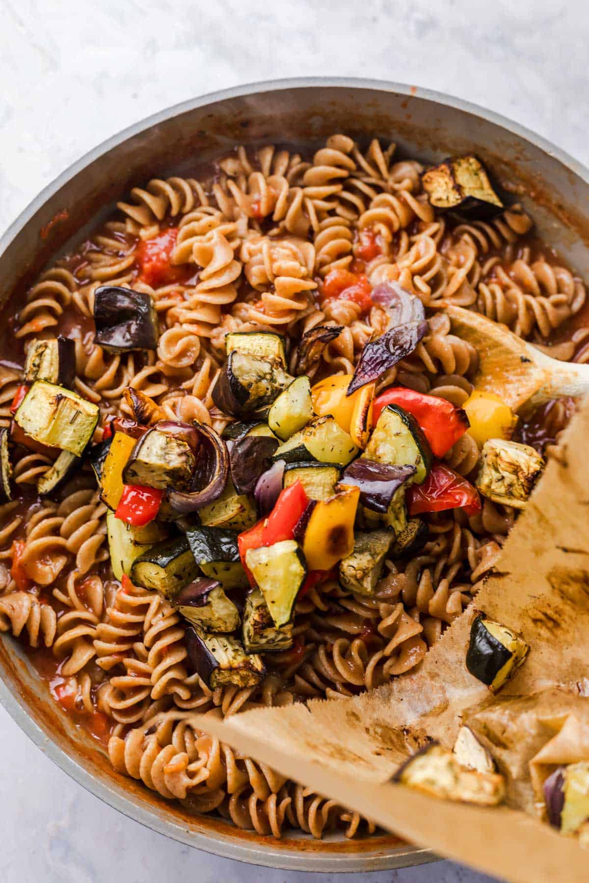 Folding roasted ratatouille vegetables into the finished one-pot pasta