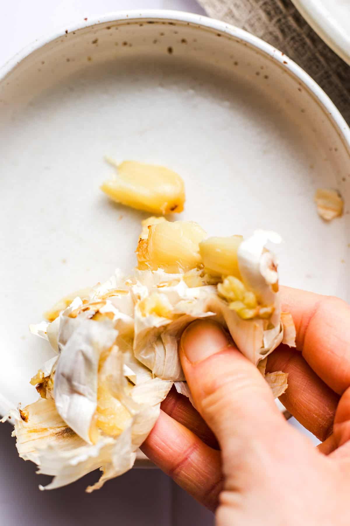 Squeezing soft roasted garlic cloves out of their skins