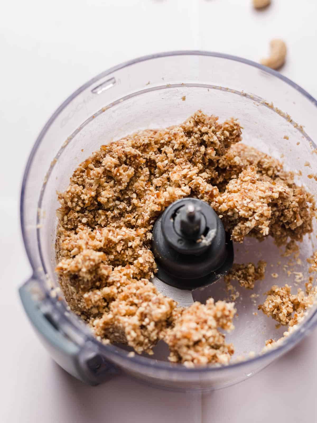Raw crust mixture with cashews and oats in a food processor