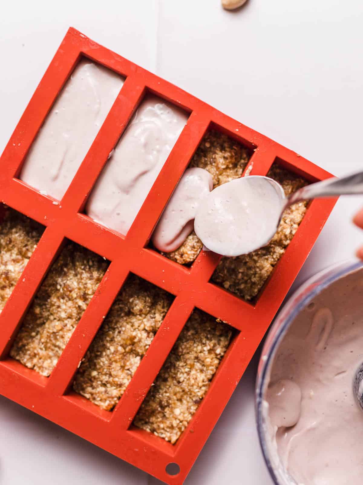 Pressing vegan yogurt crust into silicone bar molds