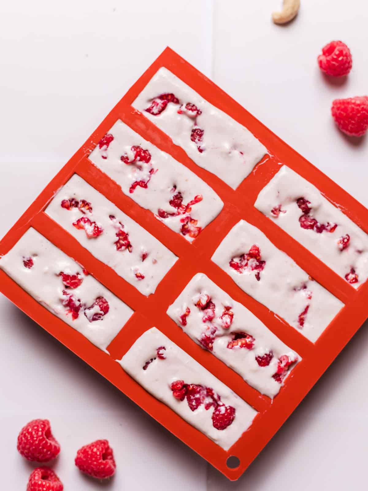 Vegan frozen yogurt bites with raspberries in silicone molds