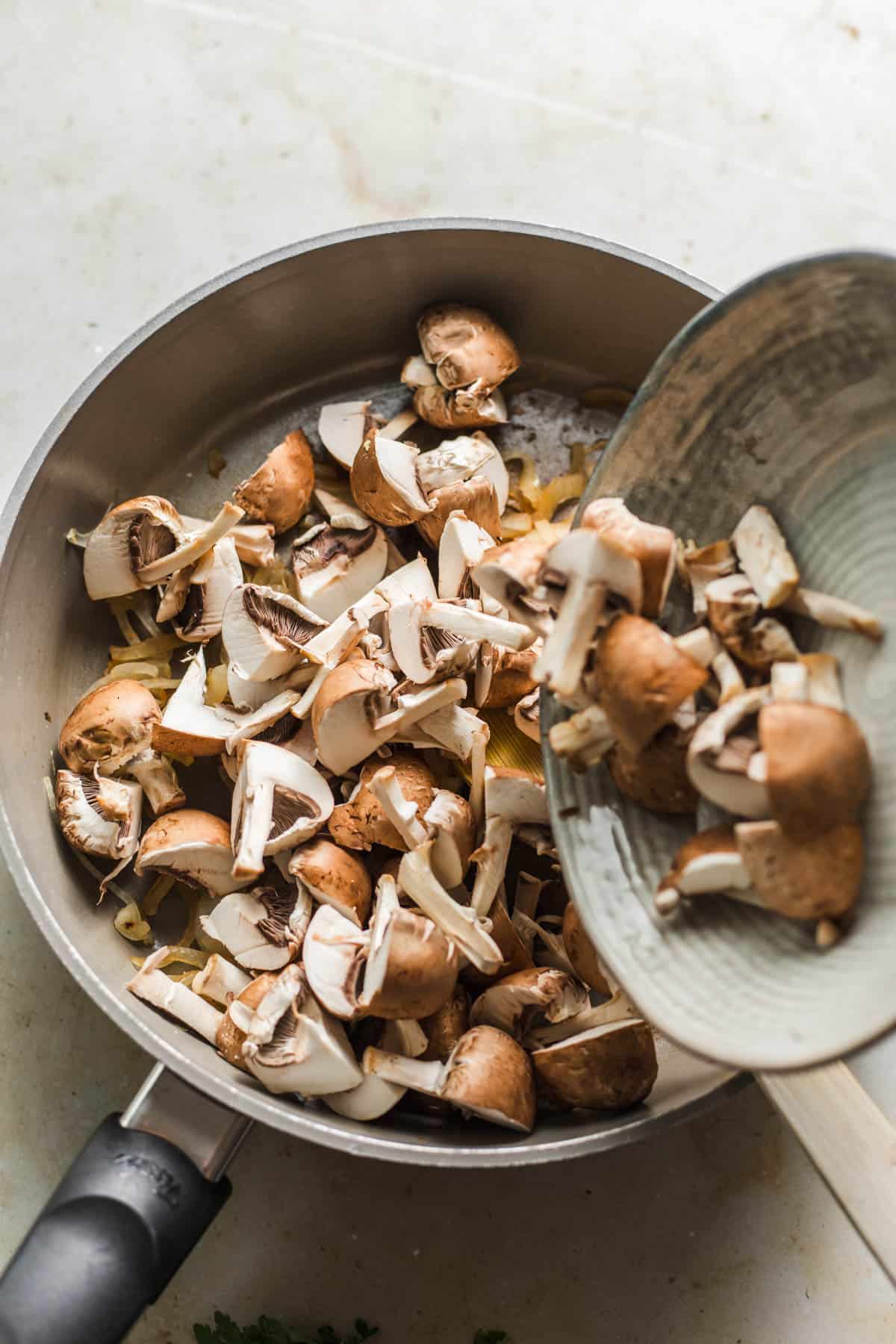 Cooking mushrooms and garlic in a skillet for vegan stroganoff