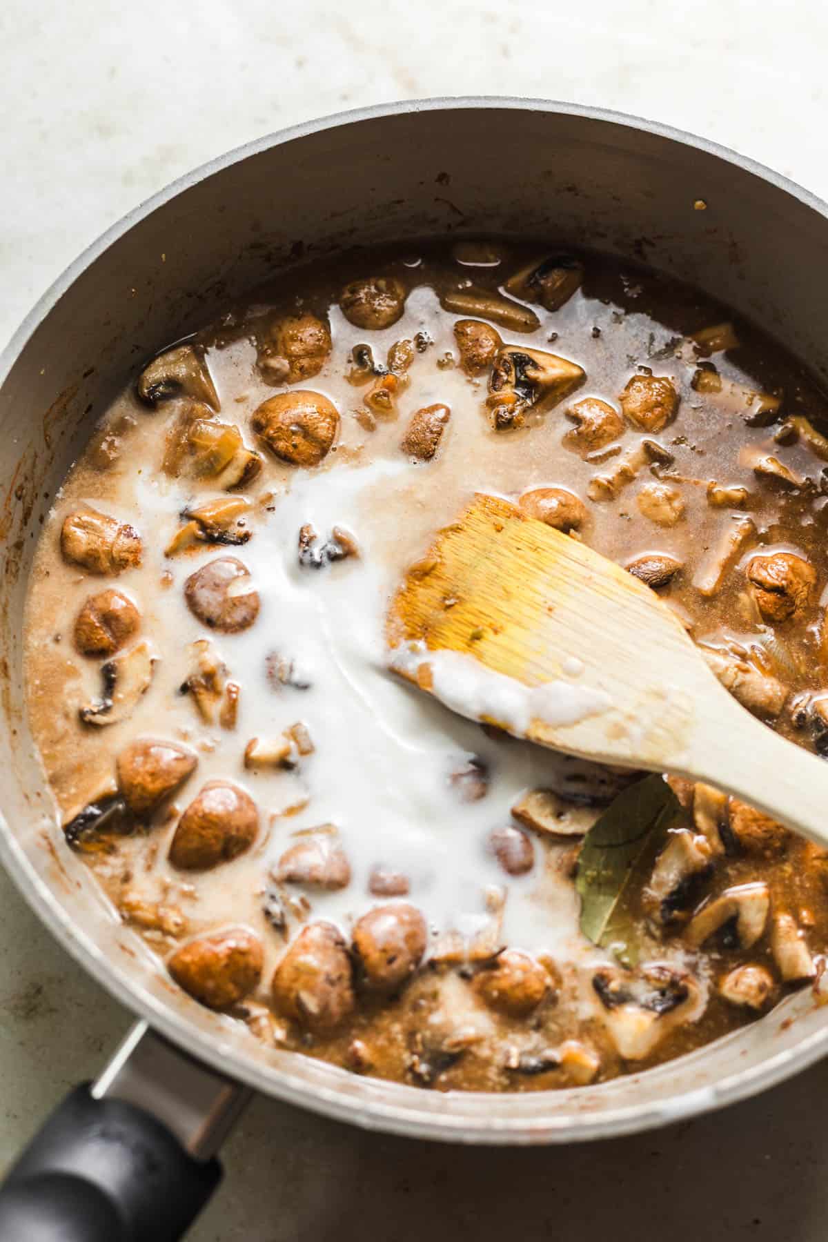Simmering vegan mushroom cream sauce with coconut milk in a skillet