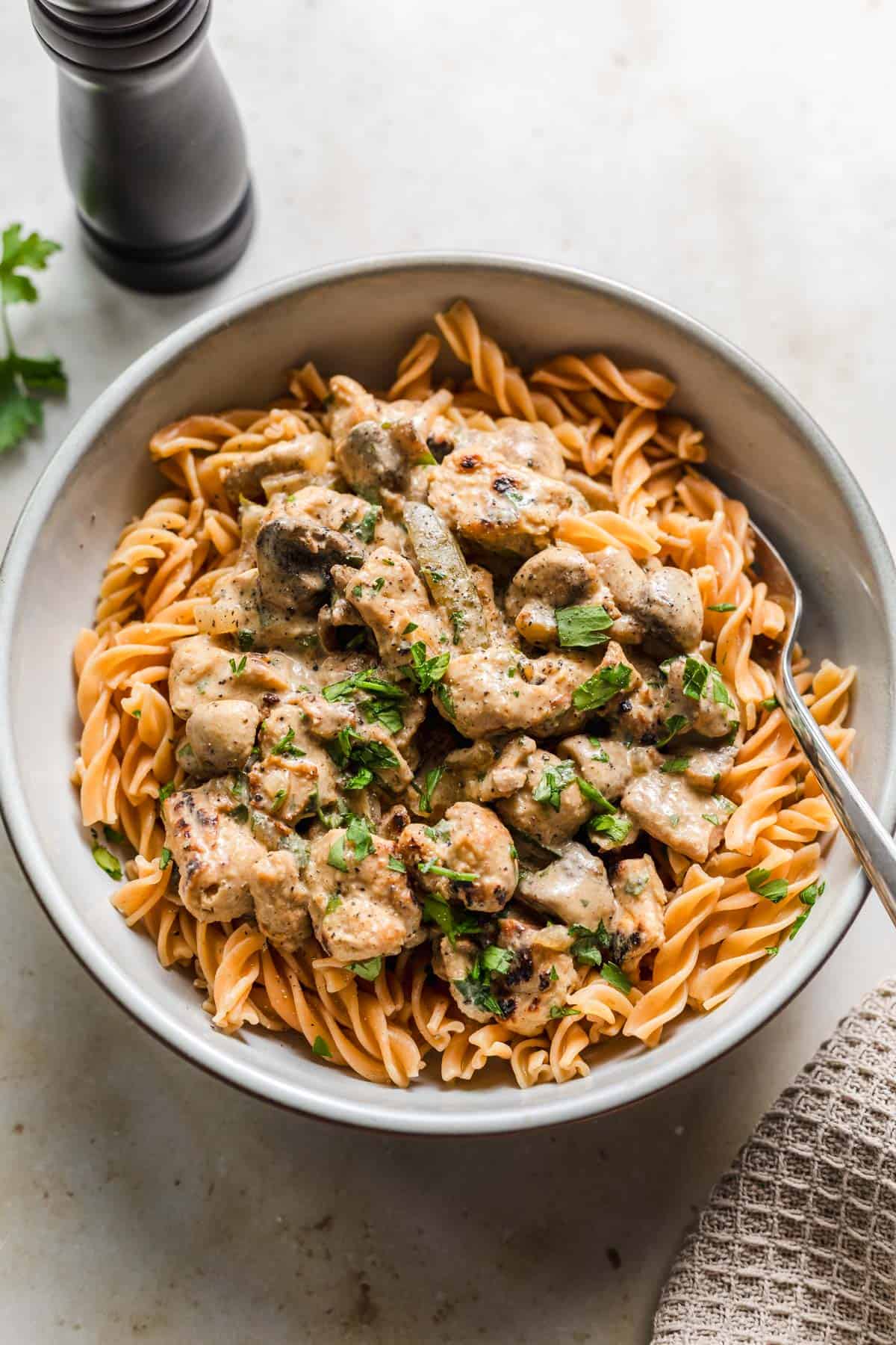 Vegan soy-mushroom stroganoff served over pasta in a bowl