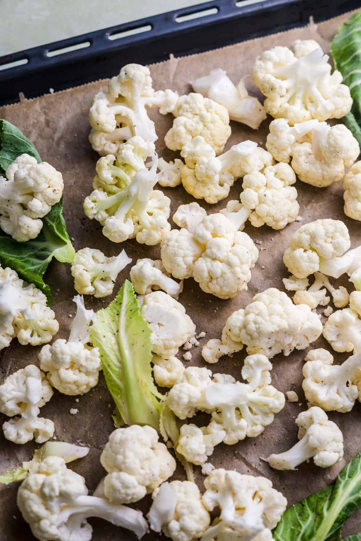 Cauliflower florets spread on a baking sheet, ready for roasting