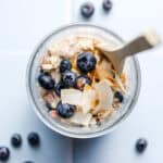 Vegan blueberry coconut Bircher muesli in a glass with a spoon