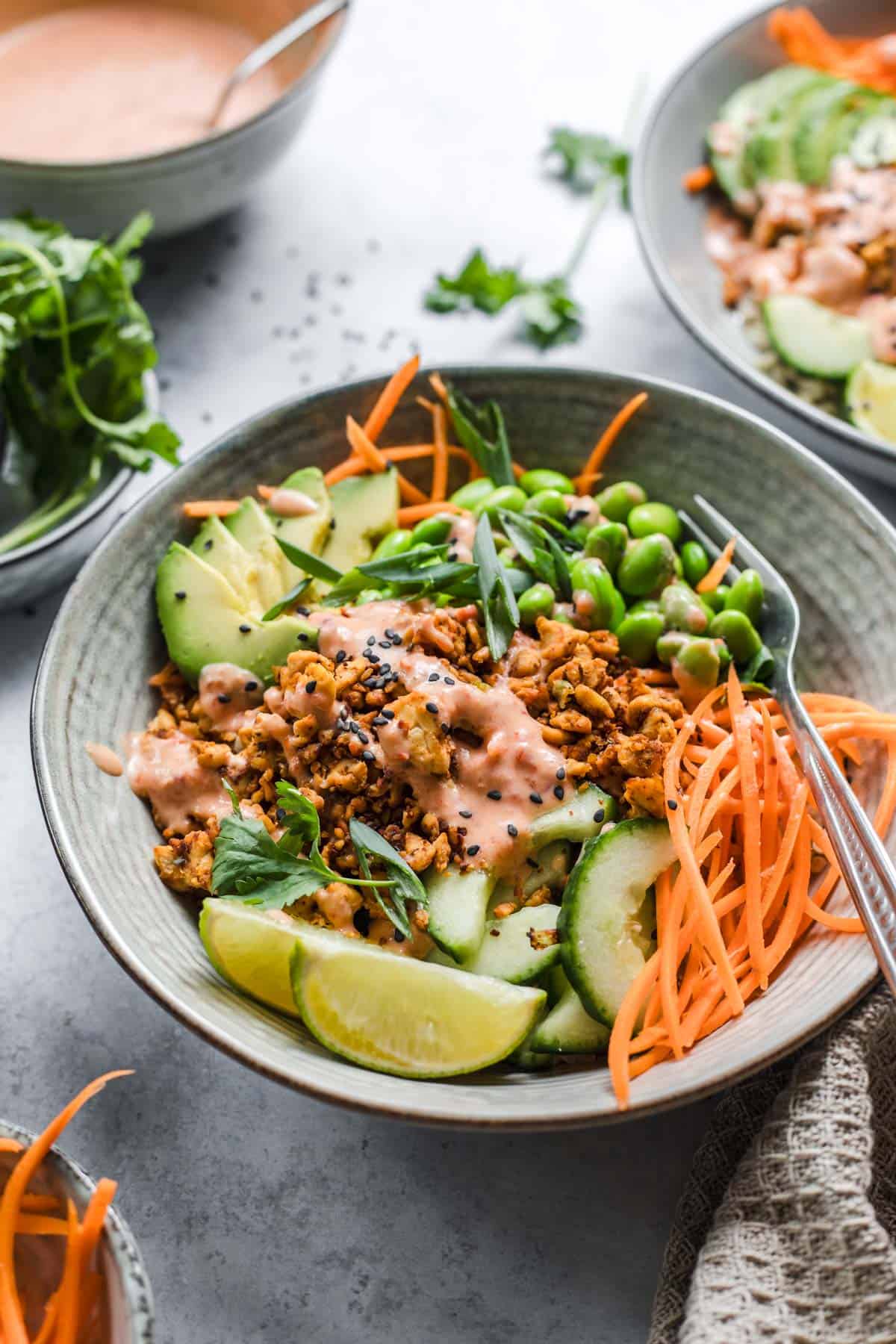 Veggie bowl with rice, tempeh and sriracha chili sauce