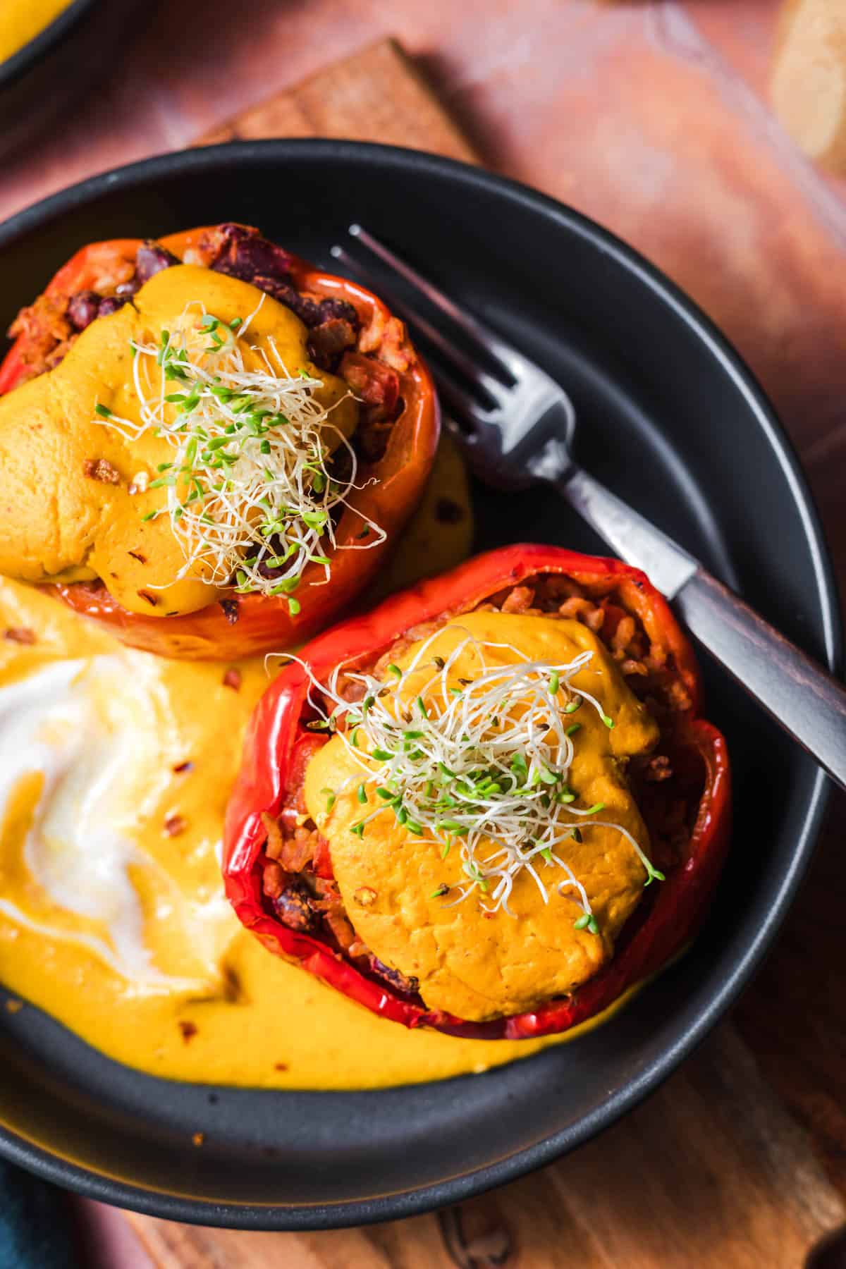 Autumnal vegan stuffed peppers with a creamy pumpkin topping
