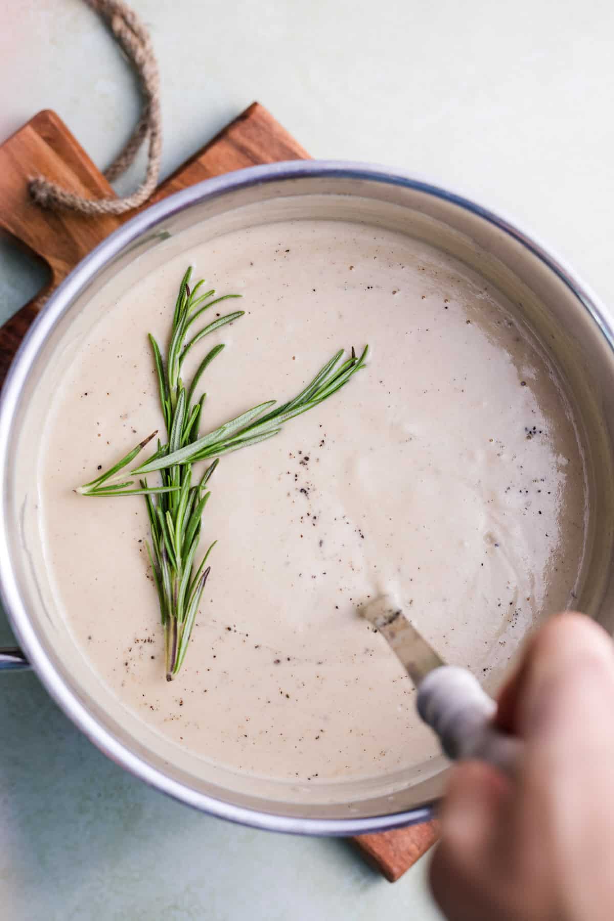 cremige suppe aus blumenkohl und maronen mit rosmarin im kochtopf