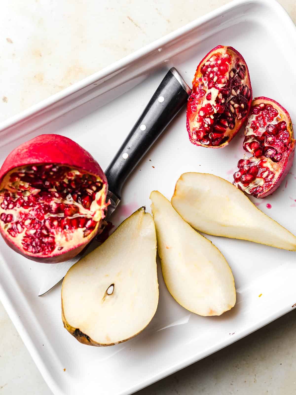 aufgeschnittener granatapfel und birne für salat