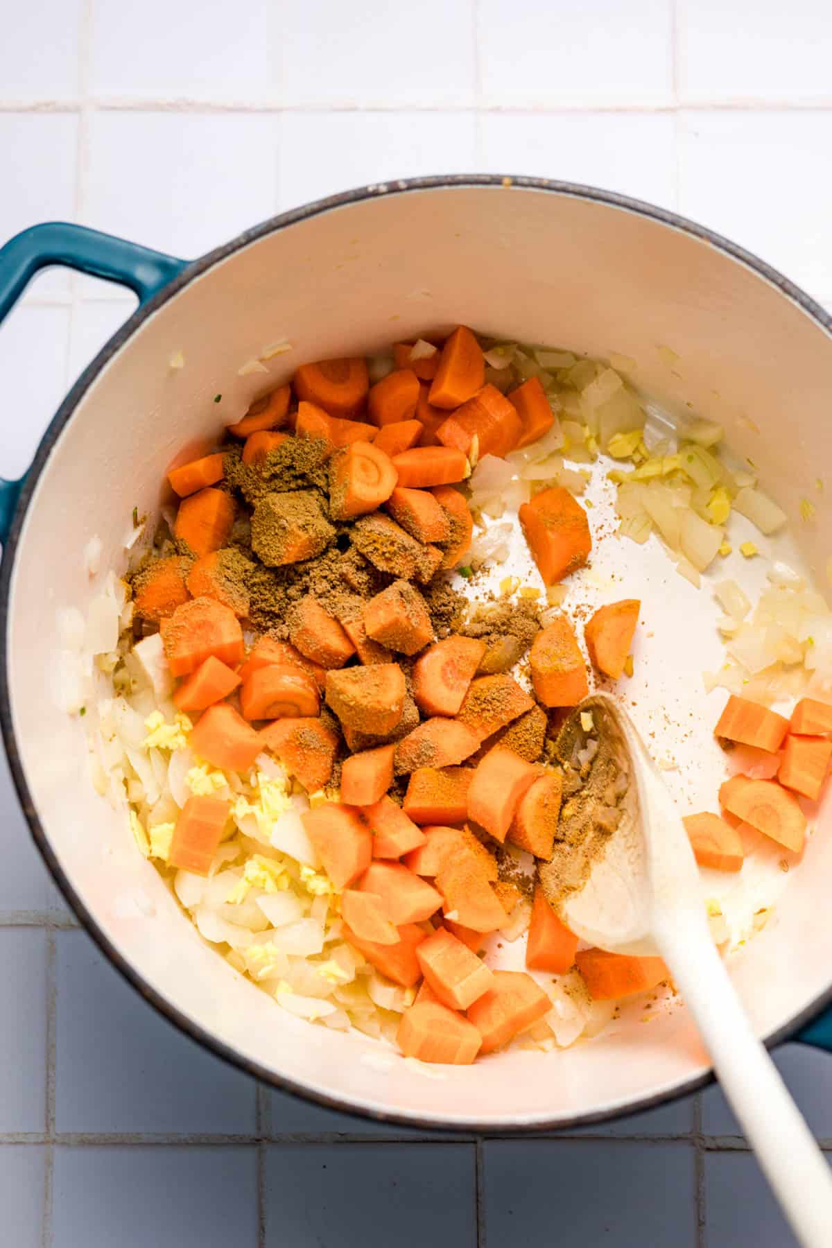 angebratene zwiebeln und möhren mit gewürzen im Topf
