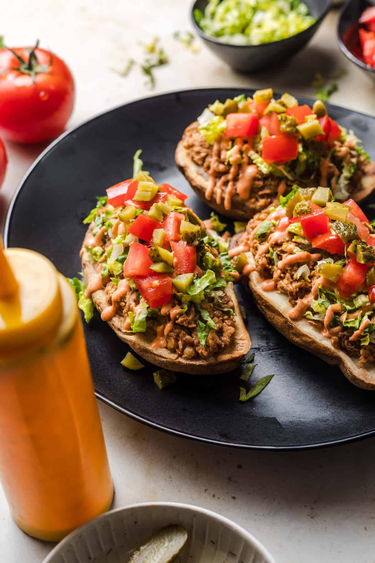 vegane gefüllte kartoffeln mit linsenfüllung, burger sauce und tomaten